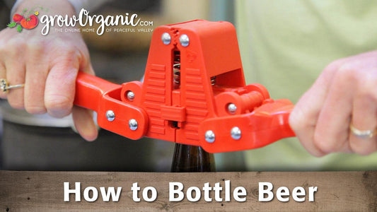 Hands operating a red bench bottle capper