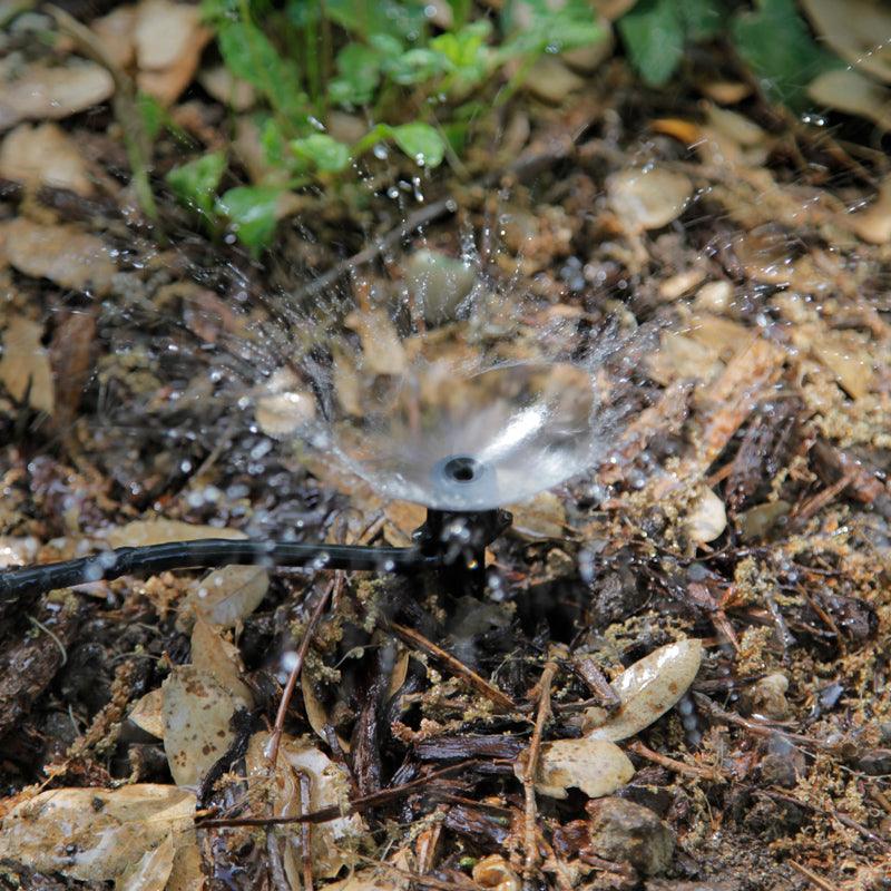 Water flowing from an irrigation emitter onto mulch