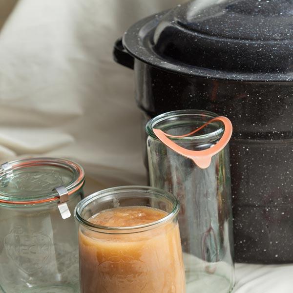 Canning jars beside a pressure canner