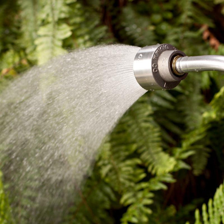 Metal hose nozzle spraying a broad fan of water