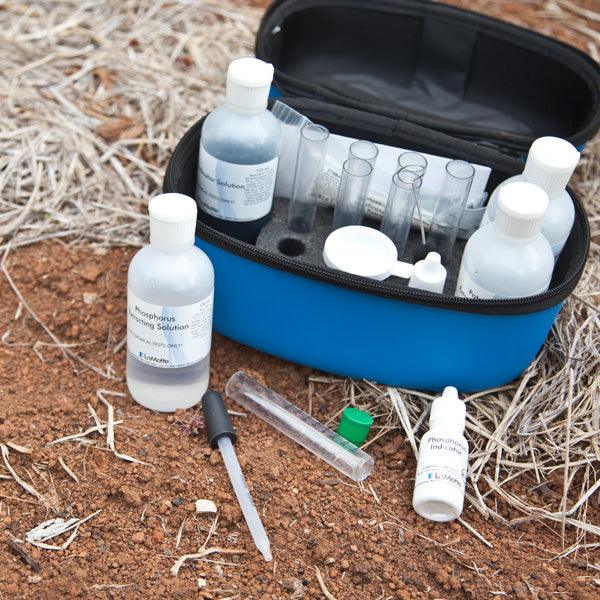 Soil-testing kit arranged on dry grass