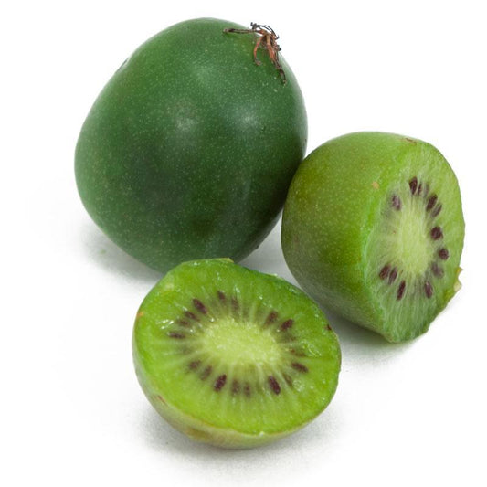 Whole and sliced hardy kiwi fruit on a white background